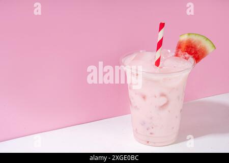 Tasty sweet watermelon milkshake or creamy slushie cocktail, garnished with watermelon slice in plastic cup, copy space Stock Photo