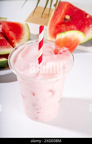 Tasty sweet watermelon milkshake or creamy slushie cocktail, garnished with watermelon slice in plastic cup, copy space Stock Photo