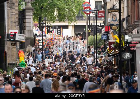 A crowd of people filling Embankment Place in London during Pride 2024 on June 29th 2024, with rainbow flags and other Pride merchandise for sale Stock Photo