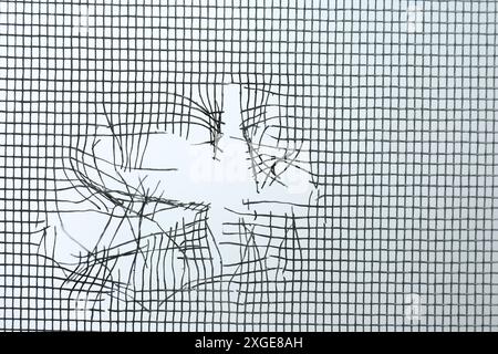Torn window screen against white background, closeup Stock Photo