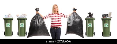 Young woman holding trash bags in front of bins isolated on white background Stock Photo