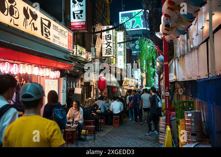 Tokyo, Japan - Jun 16, 2024: Patrons feast on Japanese cuisine at Omoide Yokocho, a popular alleyway featuring food stalls located in Shinjuku City an Stock Photo