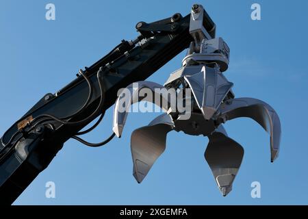 Excavator arm with metal scrap grabber. Excavator orange peel grapple. Stock Photo