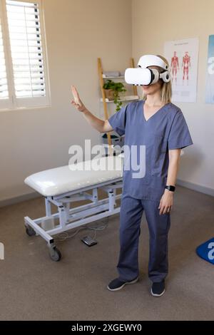 Using VR headset, medical professional in scrubs interacting in prosthetic medical clinic Stock Photo