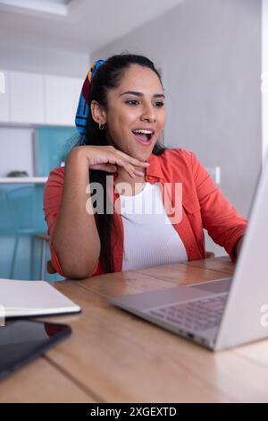 Smiling woman using laptop and enjoying online video call at home Stock Photo