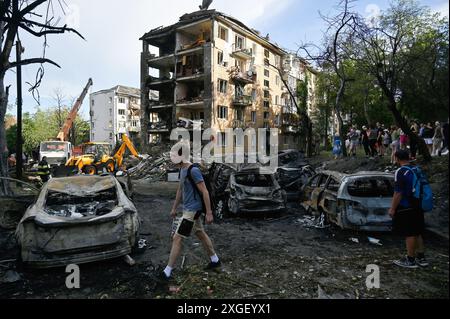 Kyiv, Ukraine. 08th July, 2024. People look at the burned cars that are standing near the destroyed residential building as a result of a rocket attack by the Russian army in Kyiv. As a result of the mass missile attack of the Russian Army on the territory of Ukraine, 36 people were killed and 140 were injured. Credit: SOPA Images Limited/Alamy Live News Stock Photo