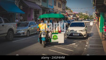 Mobile street food stall in Phuket old town. food vendor on motorbike in Thailand. Food vendor driving his motorbike to sell fast food. Stock Photo