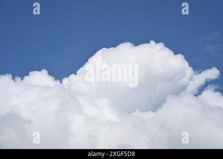 A large, fluffy white cloud against a blue sky Stock Photo