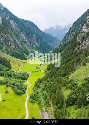 A lush green valley with a road and steep mountains covered in lush forests, Stilluptal, Austria, Germany Stock Photo