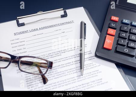 Blank Student Loan Application, calculator, pen and eyeglasses on table. Education cost concept Stock Photo