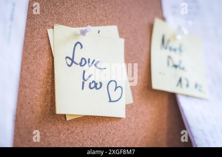 Close up of pinned note ?Love you? on cork board Stock Photo