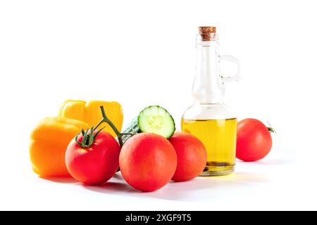 Fresh tomatoes, bell peppers, a cucumber, and olive oil, gazpacho ingredients, side view on a white background Stock Photo