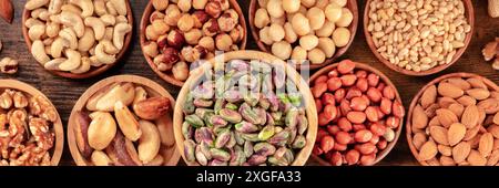 Nuts. Pistachios, walnuts, cashews, peanuts and other varieties, shot from the top in wooden bowls Stock Photo