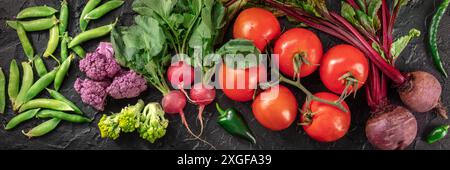 Fresh vegetable panorama, top shot on a dark background. Many healthy groceries, vegan salad ingredients Stock Photo