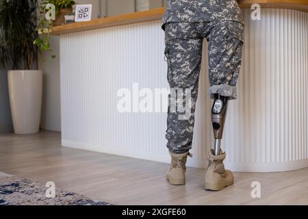 Military soldier person with prosthetic leg standing at counter in prosthetic clinic, copy space Stock Photo