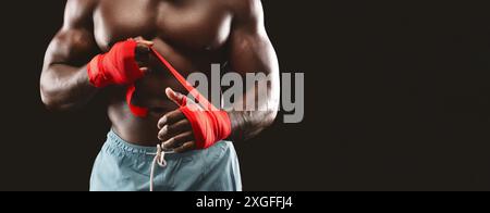 Muscular Man Wrapping Hands With Red Tape Stock Photo