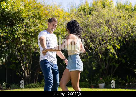 Dancing together, young couple enjoying time outdoors in garden Stock Photo