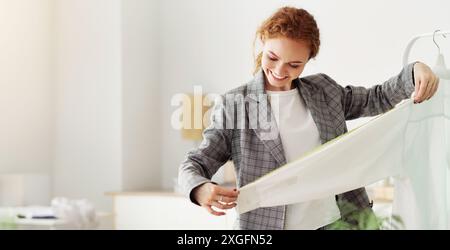 Dressmaker Measuring New Clothing Collection In Showroom Stock Photo