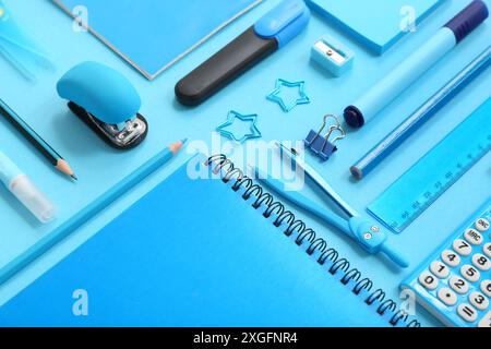 Composition with notebooks and different stationery on blue background, closeup Stock Photo