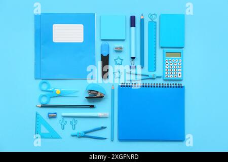 Composition with notebooks and different stationery on blue background Stock Photo