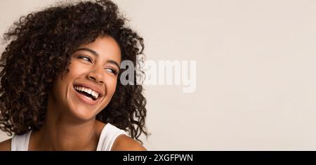 Laughing african-american woman looking away on light background Stock Photo