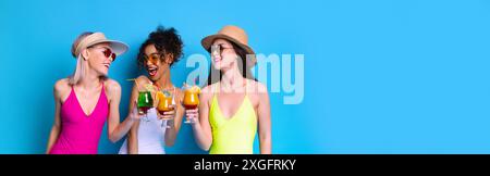 Three Women In Swimsuits Enjoying Cocktails On Blue Background Stock Photo