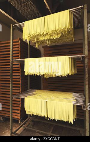 Handmade tagliatelle pasta drying on metal racks Stock Photo