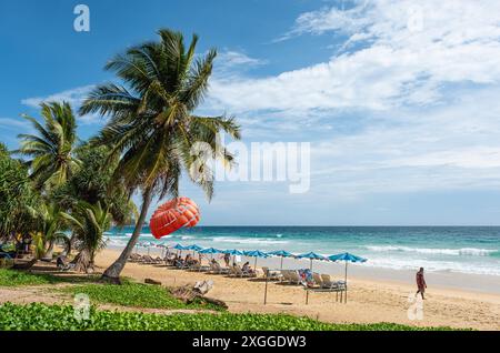 Vacation in tropical countries. Beach chairs, umbrella and palms on Patong beach Thailand. Tropical beach scenery Andaman Sea, Phuket Island. Summer t Stock Photo