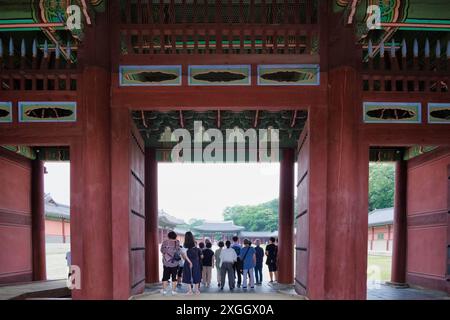 Ornate gate of a traditional Korean palace, with tourists exploring the historic site Stock Photo
