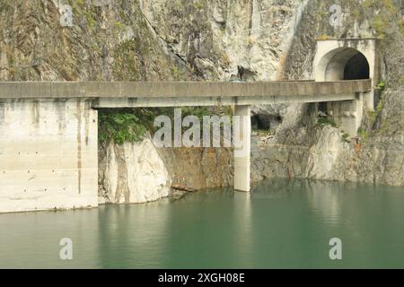 View from the Vidraru Dam on the Transfagarasan road, showing route 7041 disappearing into a tunnel. Arges County, Transylvania, Romania Stock Photo