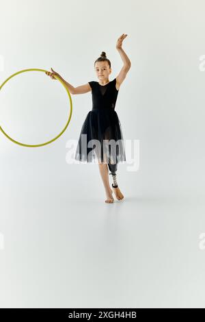 A young girl with a prosthetic leg performs gymnastics with a hoop. Stock Photo