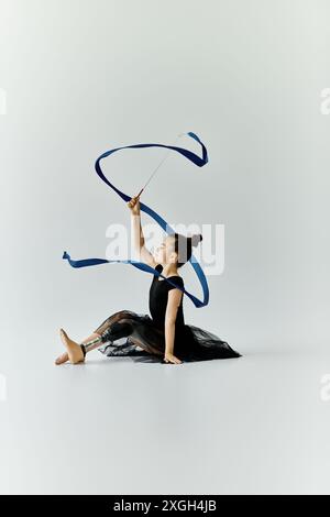 A young girl with a prosthetic leg performs a graceful ribbon routine. Stock Photo