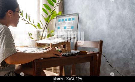 Document Management System (DMS) being setup by IT consultant working on laptop computer in office. Software for archiving, searching and managing cor Stock Photo