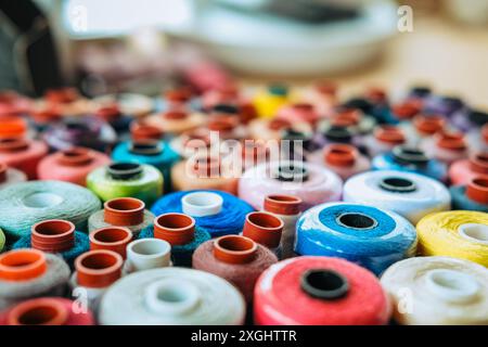 Background banner Side view many multicolored spools of thread that lie in box Stock Photo