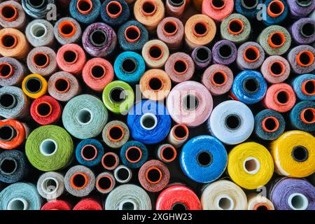 Background banner. Top view of many multicolored spools thread that lie in a box Stock Photo