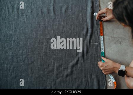 Top view of a young woman tailor marking a pattern on fabric using a chalk Stock Photo