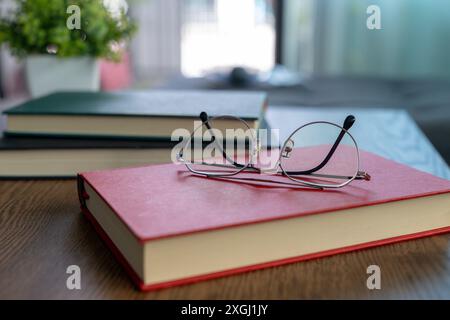 Glasses resting on a book during a break from reading Stock Photo