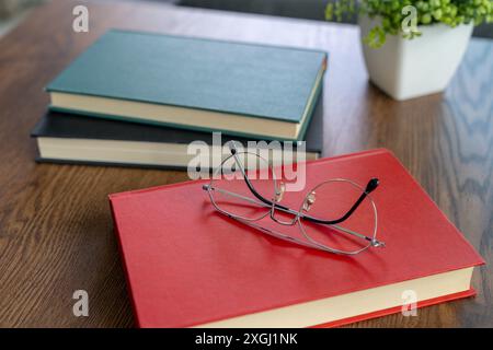 Glasses resting on a book during a break from reading Stock Photo