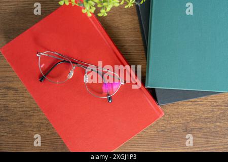 Glasses resting on a book during a break from reading Stock Photo