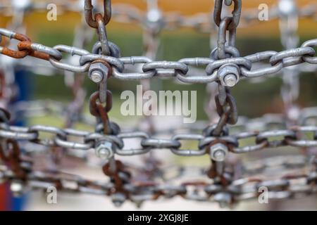 a metal chain connected by a screw and nut Stock Photo