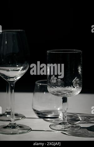 Assorted glassware for various drinks in sunlight. Stock Photo
