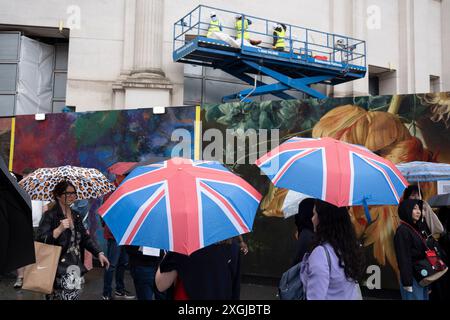 Visitors to the capital wait in a long queue to access the National Gallery in Trafalgar Square during yet another rainy day in the capital, on 9th July 2024, in London, England. Many parts of the UK have already had their average monthly rainfall  with 66cm of rain on the first seven days of the month - 139% of the total expected for the whole of July. (Photo by Richard Baker / In Pictures via Getty Images) Stock Photo