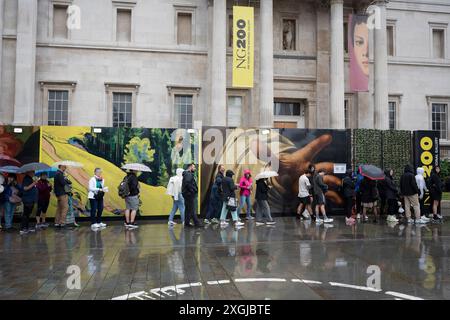 Visitors to the capital wait in a long queue to access the National Gallery in Trafalgar Square during yet another rainy day in the capital, on 9th July 2024, in London, England. Many parts of the UK have already had their average monthly rainfall  with 66cm of rain on the first seven days of the month - 139% of the total expected for the whole of July. (Photo by Richard Baker / In Pictures via Getty Images) Stock Photo