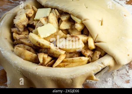 Making a pie:  Top crust.  Folded pie crust top is placed over prepared pie with excess hanging over the edge. Stock Photo