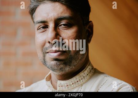 Portrait of Indian confident man looking directly at camera and smirking lightly Stock Photo