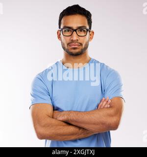 Crossed arms, glasses and portrait of man in studio with pride for web development career. Serious, IT and male programmer from Indonesia with Stock Photo