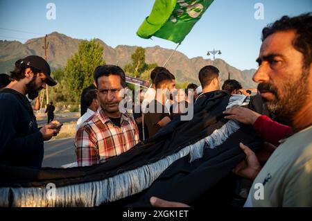 Kashmiri Shia Muslims prepare a religious flag to install on a road ...