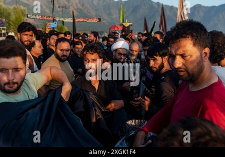 Kashmiri Shia Muslims prepare a religious flag to install on a road ...