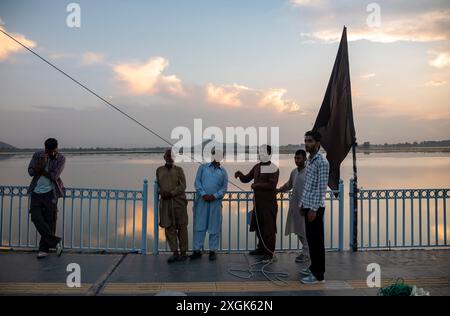 Kashmiri Shia Muslims erect a tall religious flag on a road during ...