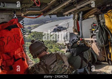 May 26, 2024 - New York City, New York, USA - Navy explosive ordnance disposal (EOD) technicians from Explosive Ordnance Disposal Mobile Units (EODMU) 2 and 6 fly over New York in an MH-60S Knighthawk attached to the ''Tridents'' of Helicopter Sea Combat Squadron 9, after a fast roping display and community outreach event at Liberty State Park during Fleet Week New York 2024, May 26, 2024. Fleet Week New York is a week-long, city-wide event with over 2,300 Sailors, Marines, and Coast Guard personnel participating in the 36th year of this naval tradition showcasing our naval fleet and forces to Stock Photo